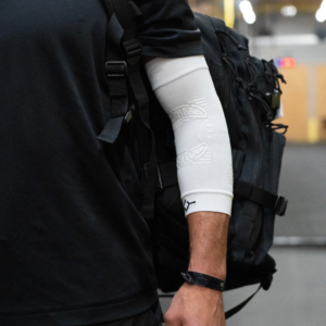 Man wearing the white ELBOW Support Premier Padel brace on his arm